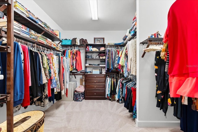 walk in closet featuring light colored carpet