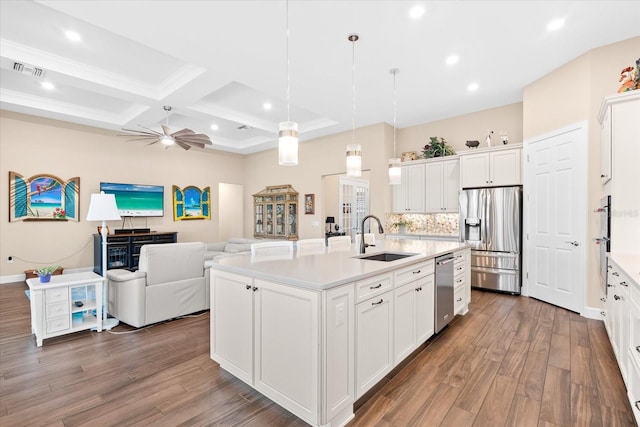 kitchen featuring a center island with sink, white cabinetry, appliances with stainless steel finishes, sink, and dark wood-type flooring