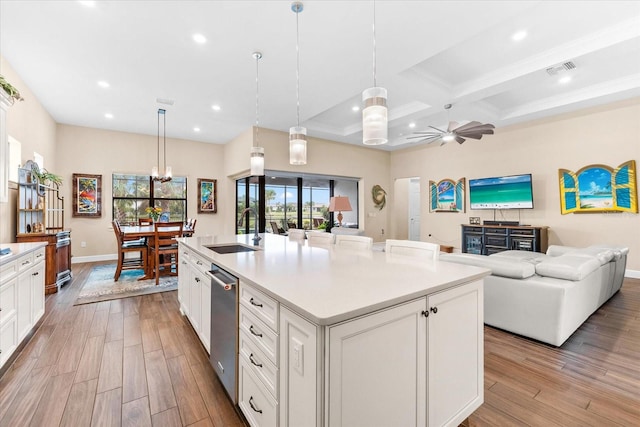 kitchen featuring an island with sink, ceiling fan, pendant lighting, and light wood-type flooring