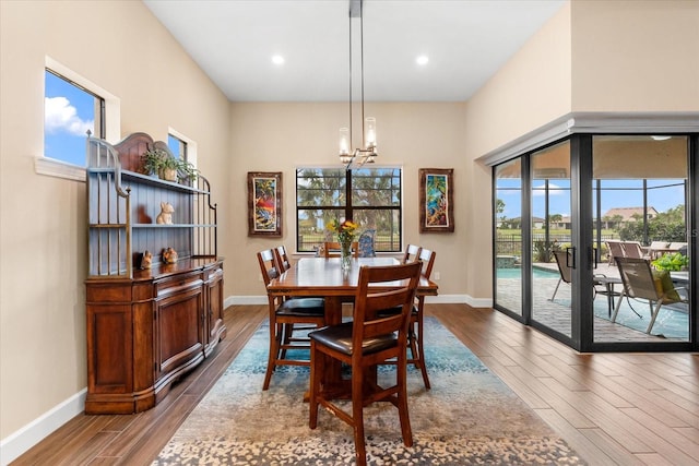 dining space with hardwood / wood-style flooring, a healthy amount of sunlight, and a notable chandelier