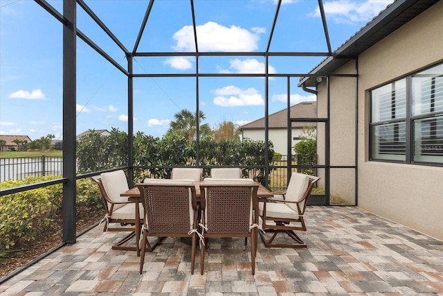 sunroom featuring a water view