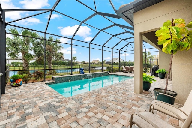 view of swimming pool with glass enclosure, a patio area, a water view, and pool water feature