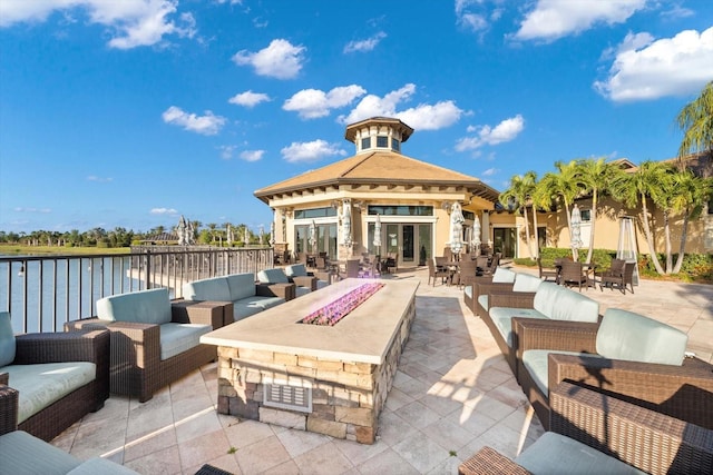 view of patio featuring an outdoor living space with a fire pit, a gazebo, and a water view