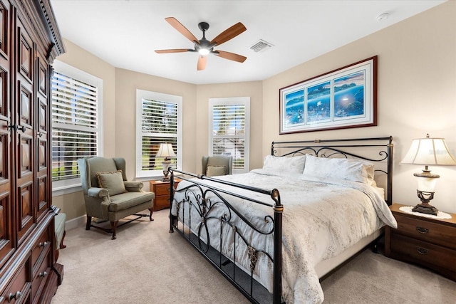 bedroom with visible vents, light carpet, baseboards, and a ceiling fan