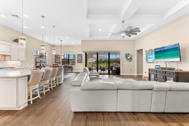 living room featuring light wood-type flooring, baseboards, and a ceiling fan