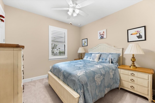 bedroom with light carpet, a ceiling fan, and baseboards