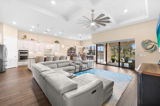 living room with dark wood-style floors, beamed ceiling, coffered ceiling, and a ceiling fan