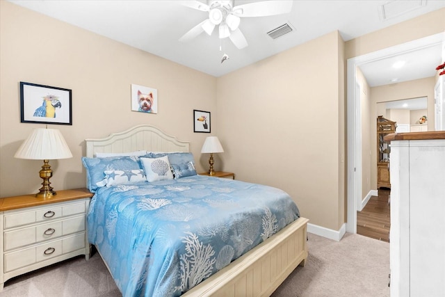 bedroom with visible vents, light carpet, baseboards, and ceiling fan