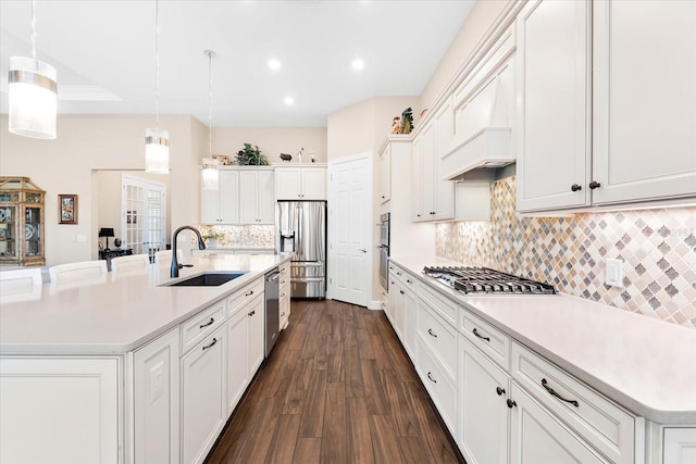 kitchen featuring dark wood-style flooring, stainless steel appliances, a sink, light countertops, and white cabinetry