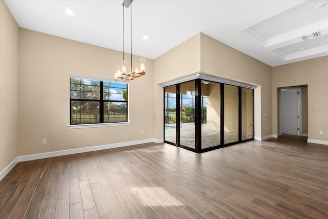 unfurnished room featuring recessed lighting, baseboards, an inviting chandelier, and wood finished floors