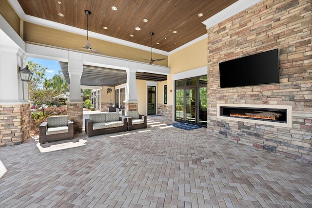 view of patio with an outdoor living space with a fireplace and a ceiling fan