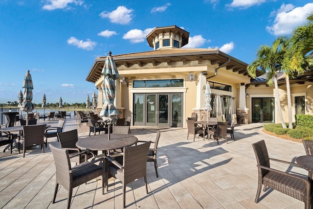 back of property with a patio area, french doors, and stucco siding