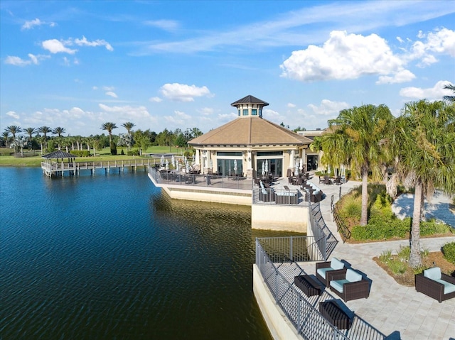 view of dock with a gazebo, a patio area, and a water view