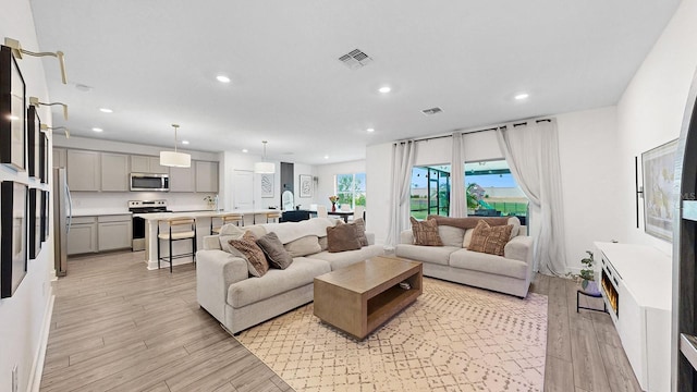 living room with sink and light wood-type flooring