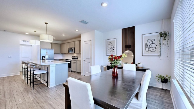 dining room with sink and light hardwood / wood-style flooring