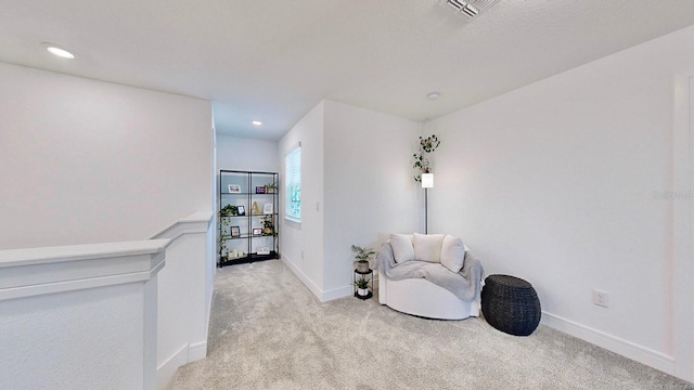 sitting room featuring light colored carpet