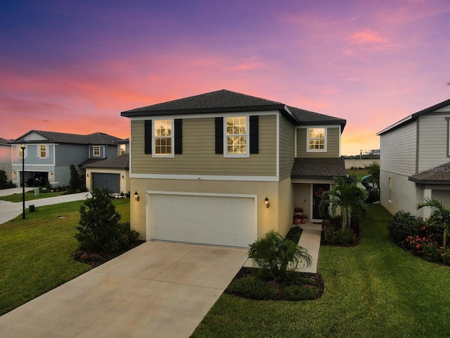 view of front of home with a garage and a lawn