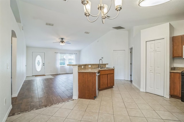 kitchen with ceiling fan with notable chandelier, light tile patterned floors, dishwasher, hanging light fixtures, and lofted ceiling