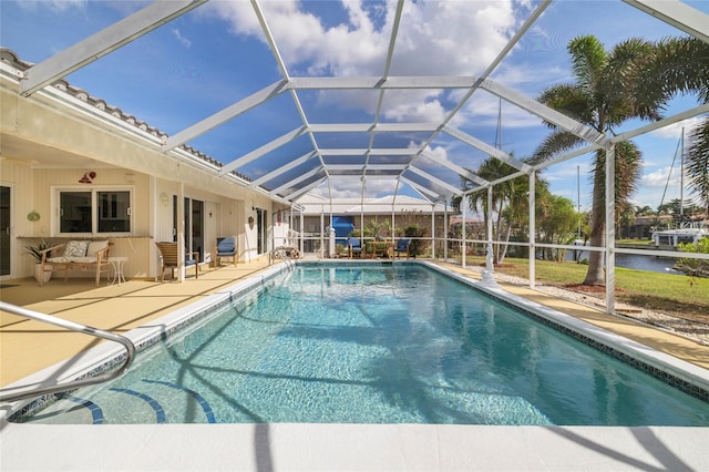 view of pool featuring a water view, glass enclosure, and a patio area