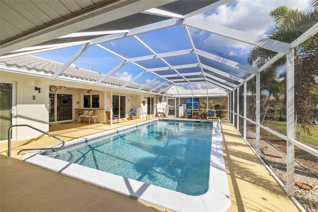 view of swimming pool with ceiling fan, glass enclosure, and a patio area