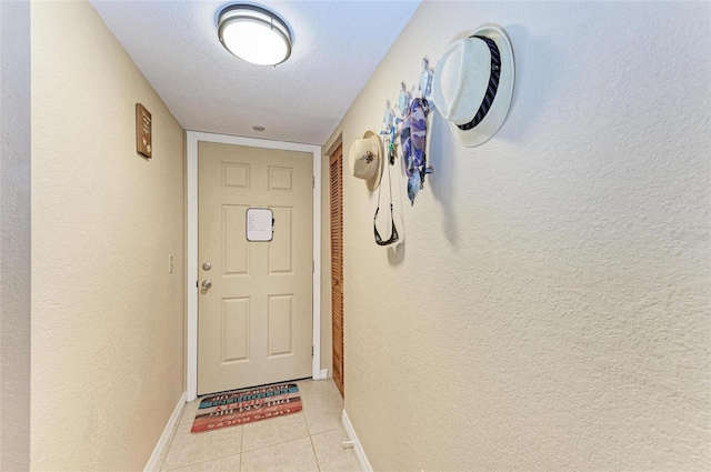 entryway with a textured ceiling and light tile patterned flooring