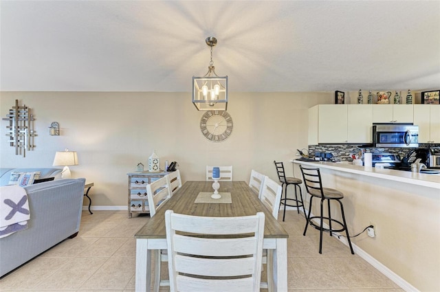 tiled dining area featuring an inviting chandelier