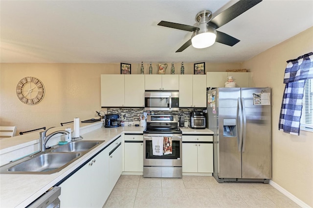 kitchen featuring light tile patterned flooring, stainless steel appliances, decorative backsplash, sink, and ceiling fan