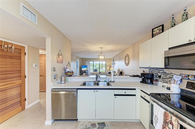 kitchen featuring hanging light fixtures, white cabinetry, sink, and appliances with stainless steel finishes