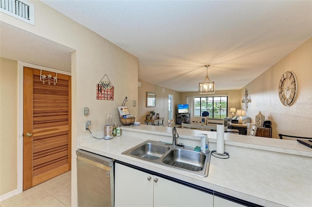 kitchen with white cabinetry, sink, light tile patterned floors, hanging light fixtures, and dishwasher