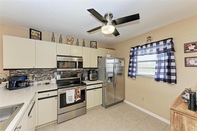 kitchen with white cabinetry, stainless steel appliances, a textured ceiling, and backsplash