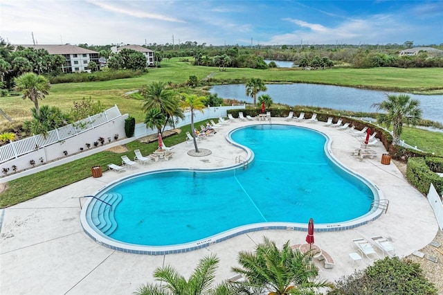 view of swimming pool with a water view, a lawn, and a patio area