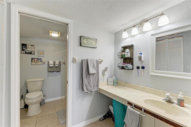 bathroom featuring toilet, sink, tile patterned floors, and a textured ceiling