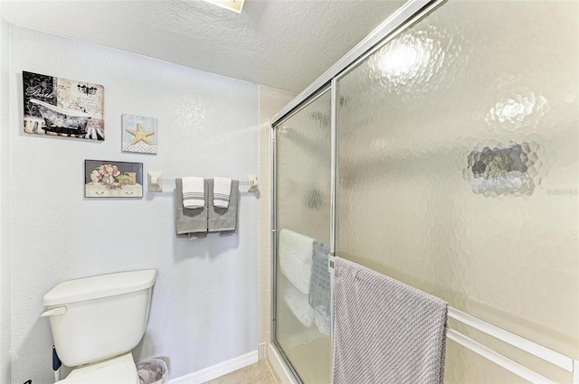 bathroom featuring a shower with shower door, a textured ceiling, and toilet