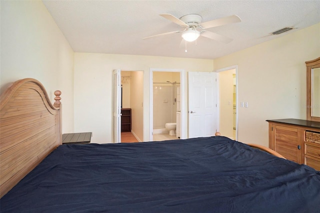 unfurnished bedroom featuring a textured ceiling, ceiling fan, and ensuite bath