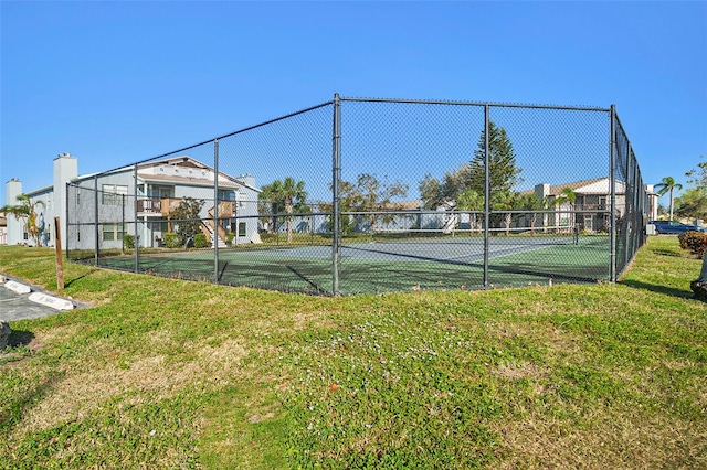 view of sport court featuring a lawn