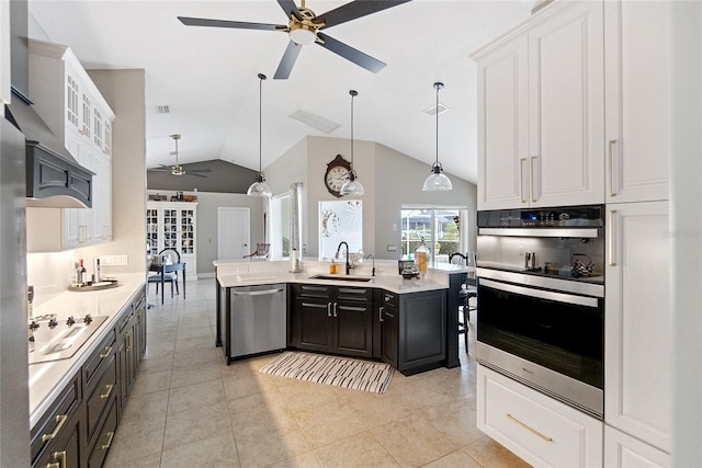 kitchen with pendant lighting, sink, white cabinets, a kitchen island with sink, and stainless steel appliances