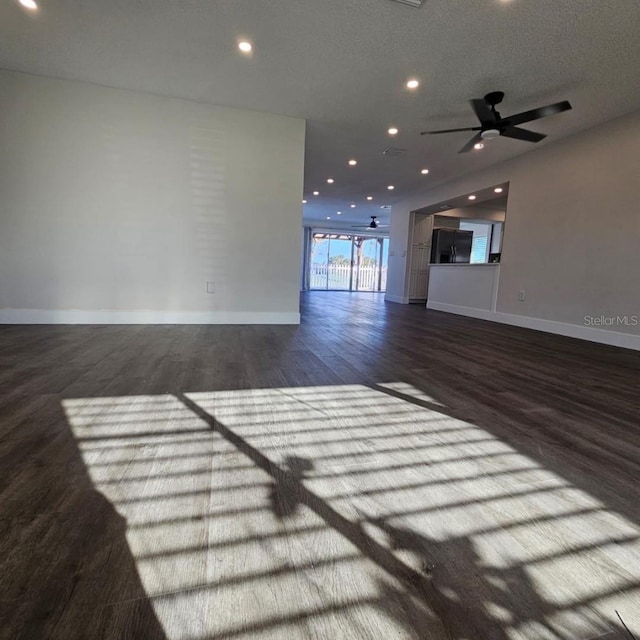 unfurnished living room with ceiling fan, a textured ceiling, and hardwood / wood-style flooring