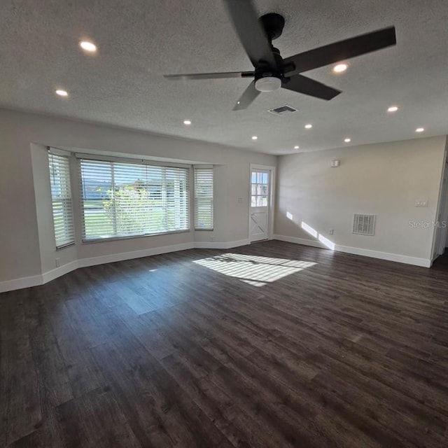 unfurnished living room with ceiling fan, dark hardwood / wood-style flooring, and a textured ceiling