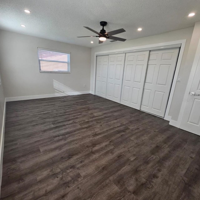 unfurnished bedroom featuring a textured ceiling, dark wood-type flooring, and ceiling fan