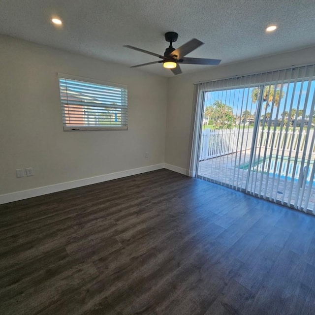 empty room featuring ceiling fan, dark hardwood / wood-style floors, and a textured ceiling