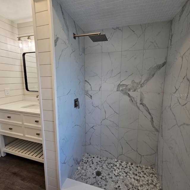 bathroom with vanity and a tile shower