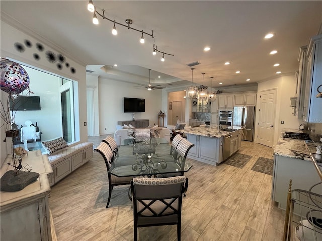 dining room with crown molding, light hardwood / wood-style floors, and ceiling fan with notable chandelier