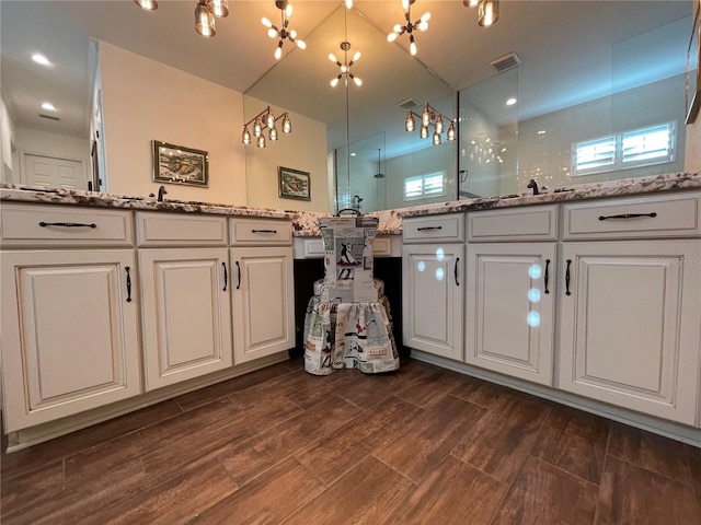 bathroom featuring hardwood / wood-style floors, vanity, and a shower