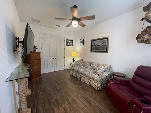 living room featuring dark hardwood / wood-style floors, ceiling fan, and ornamental molding