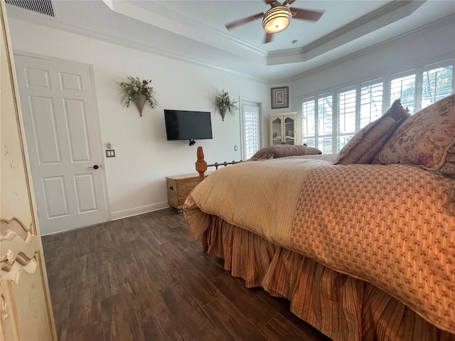 bedroom featuring dark hardwood / wood-style floors, a raised ceiling, ceiling fan, and crown molding