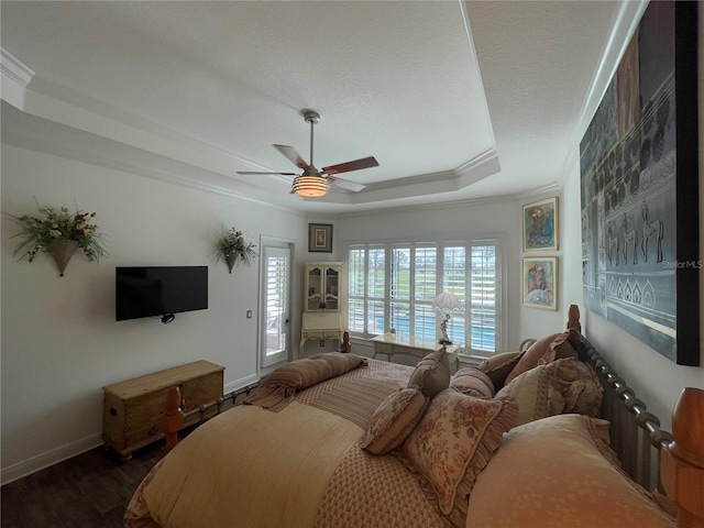 bedroom featuring dark wood-type flooring, access to outside, a raised ceiling, ceiling fan, and ornamental molding