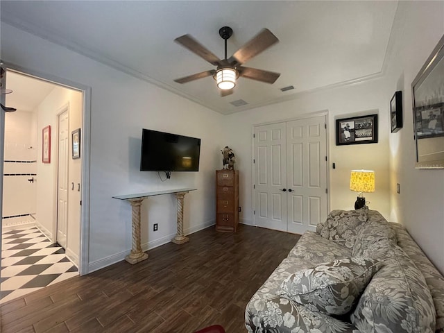 living room with ceiling fan, wood finished floors, visible vents, and baseboards