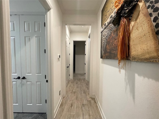 hallway with light wood-style floors and baseboards