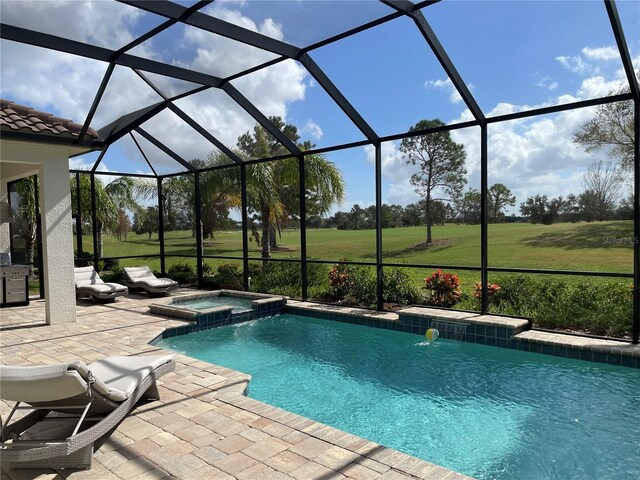 view of swimming pool with a patio, a lawn, a pool with connected hot tub, and glass enclosure