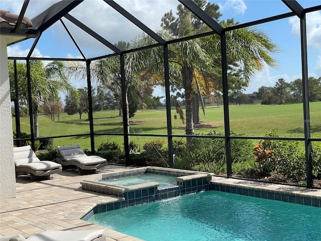 view of pool with glass enclosure, a pool with connected hot tub, a patio area, and a lawn